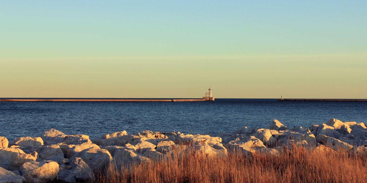 Scenic view of Prince Edward Island coastline with a lighthouse, representing a new beginning in Canada
